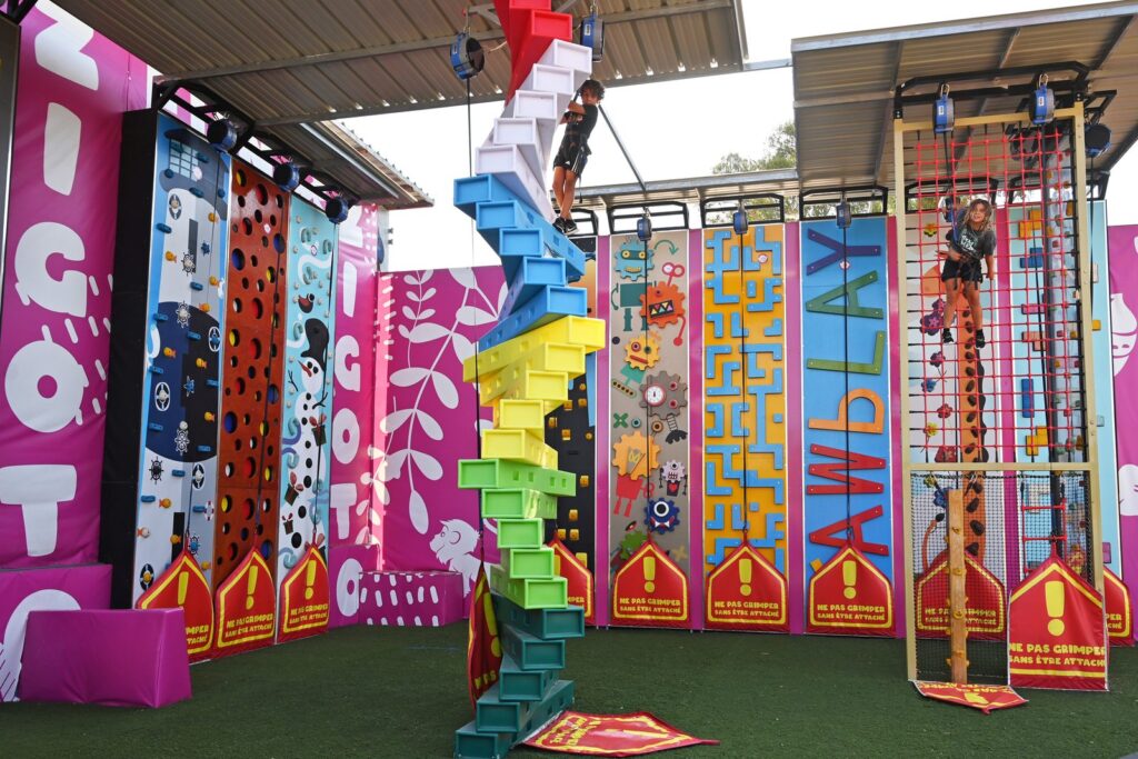 Kinderen spelen op de klimwanden van Zigoto in Oasis Village, met harnas en automatische zekering