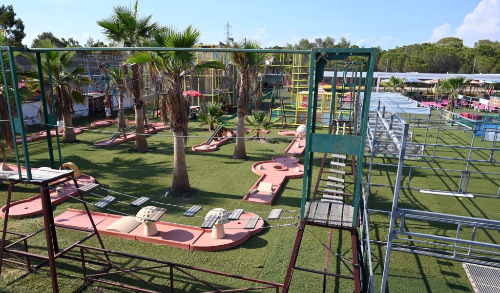 Minigolfbaan en speeltoestellen bij Play City in Oasis Village, onder de palmbomen