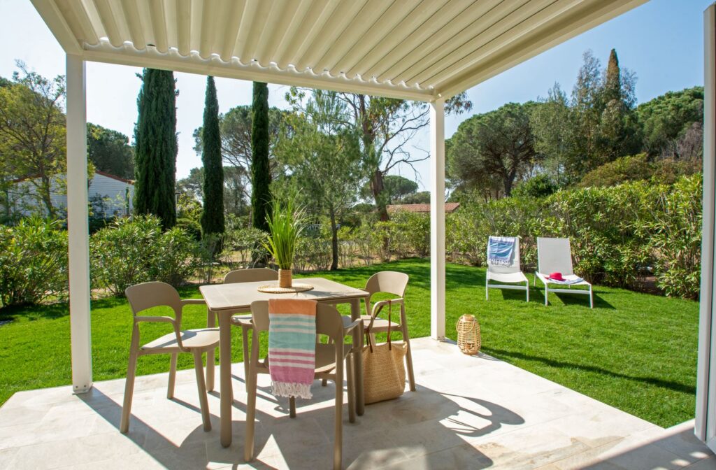 Overdekt terras met pergola en tuinmeubilair voor een accommodatie van Oasis Village in Puget-sur-Argens