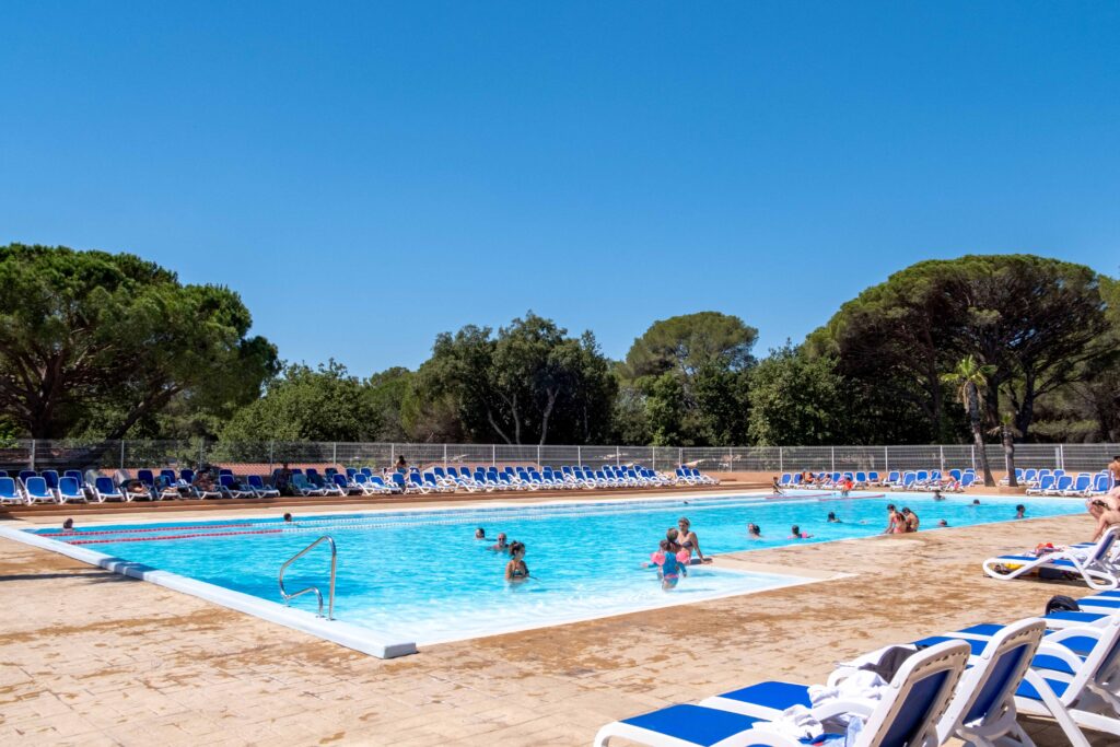 Groot buitenzwembad in het waterpark Oasis Village, omgeven door ligstoelen en parasoldennen
